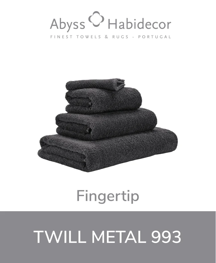 Abyss Twill towel in a modern metallic gray color neatly stacked with other towels